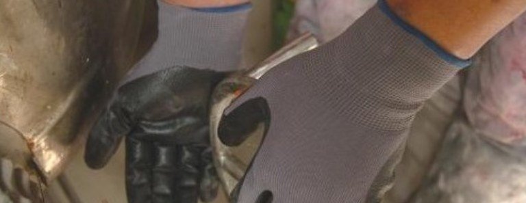 Gloved hands working on rotating equipment
